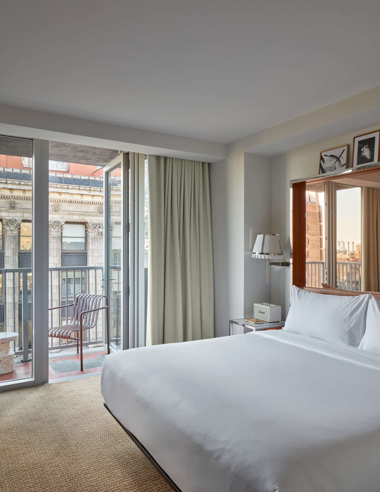 Studio Balcony King room featuring open door to balcony, king sized bed and mirrored headboard.